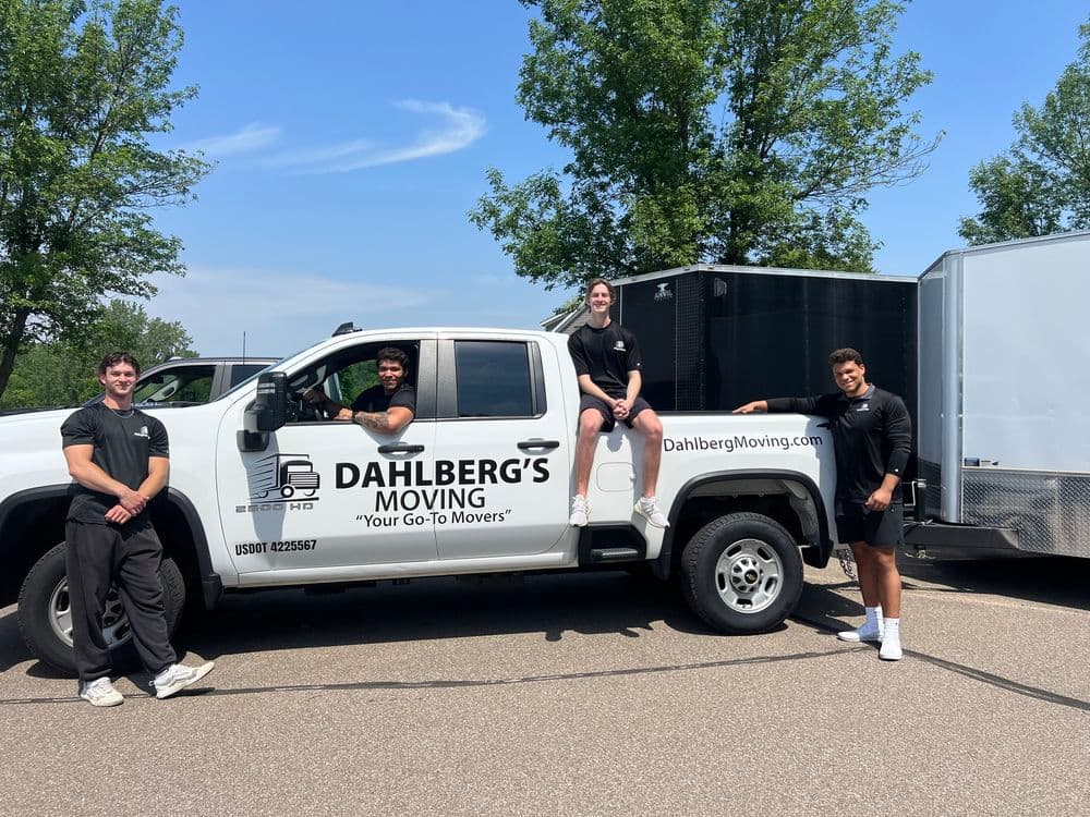 Dahlberg's Moving truck with team members posing outdoors, promoting moving services.